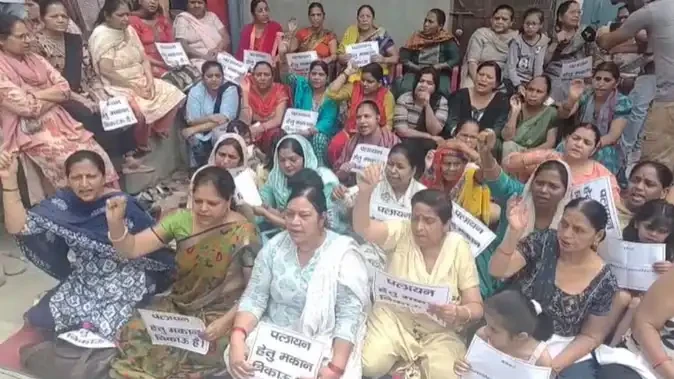 सेंट्रल मार्केट विवाद: पलायन के पोस्टर लेकर धरने पर बैठी महिलाएं
